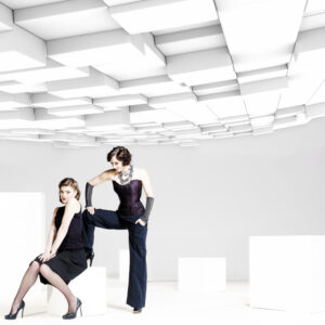 2 Models in schwarz in abstraktem weißen Studio-Setting